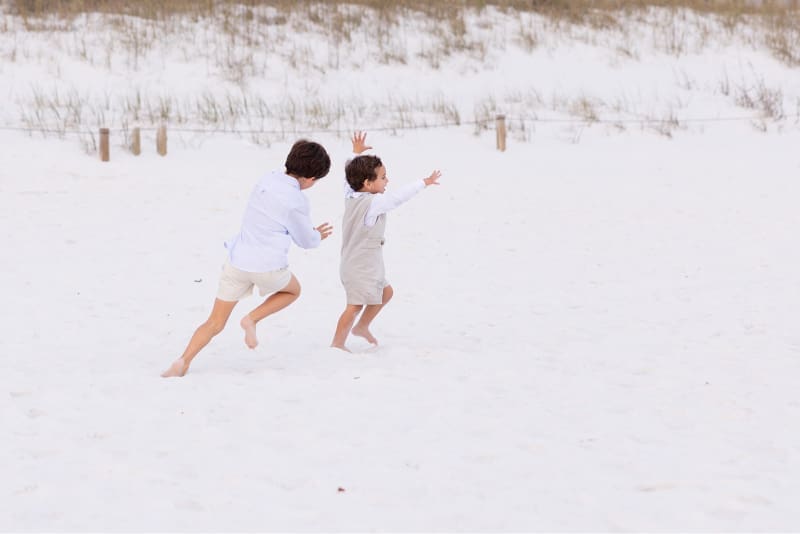 Children running on white sand dunes, enjoying one of the best beaches near Cape Coral.
