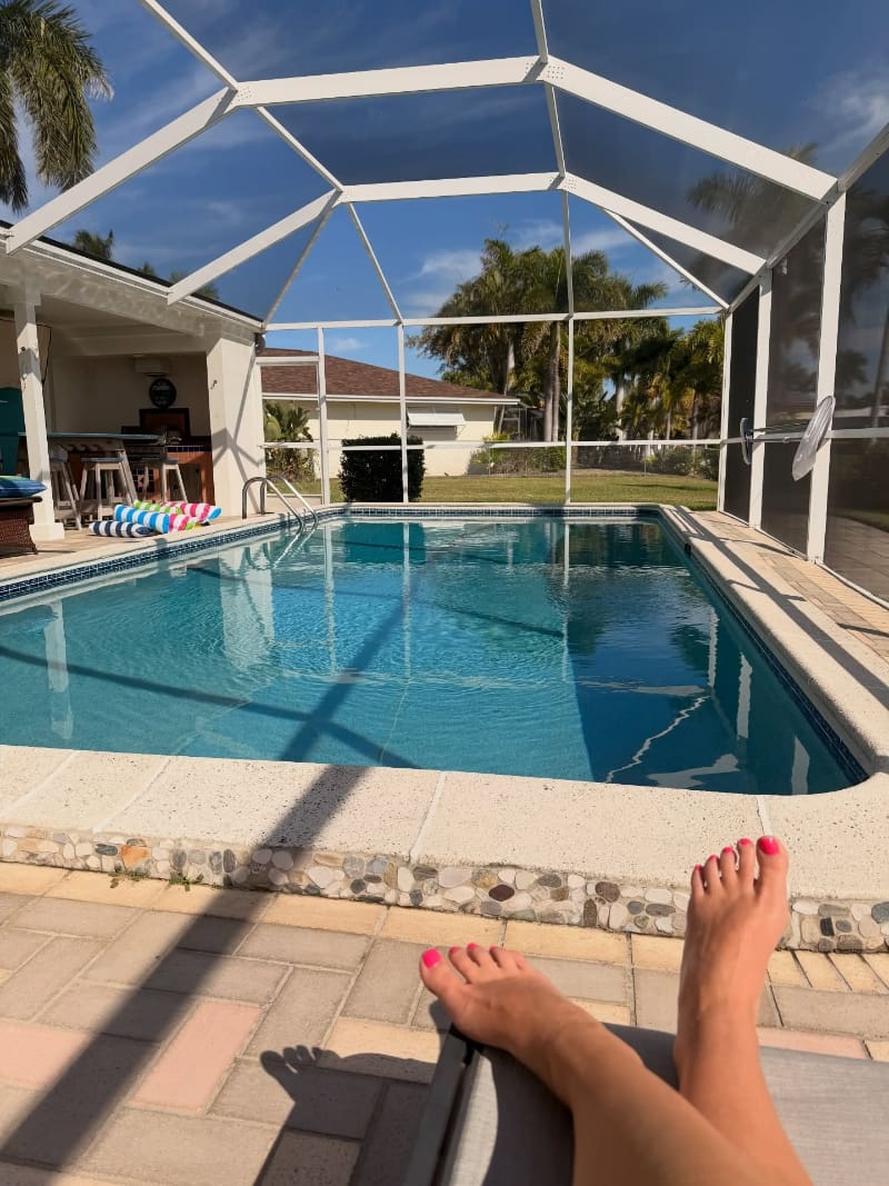 Relaxing poolside view showing bare feet and calm water, one of the simple things to do in Cape Coral, Florida.