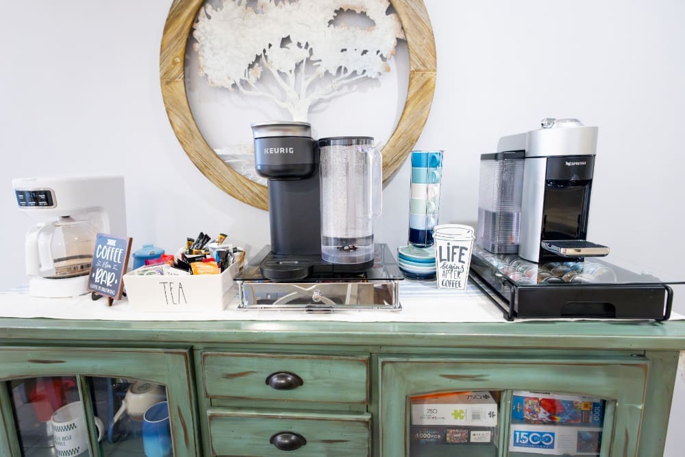 Coffee station with espresso machine, tea setup, and mugs arranged on a rustic cabinet for easy mornings