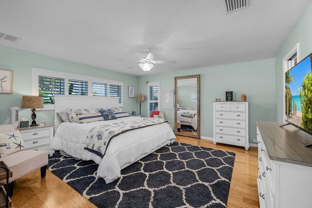 Bright coastal bedroom with soft colors, large bed, and natural light creating a calm and relaxing space