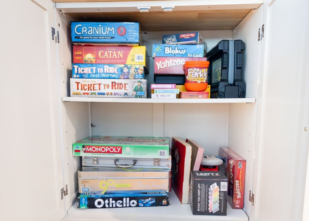 Cabinet filled with board games and puzzles, perfect for relaxed family nights indoors.