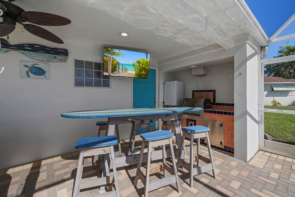 Outdoor patio with surfboard table and grill, relaxing space at one of the best Florida family vacation spots.
