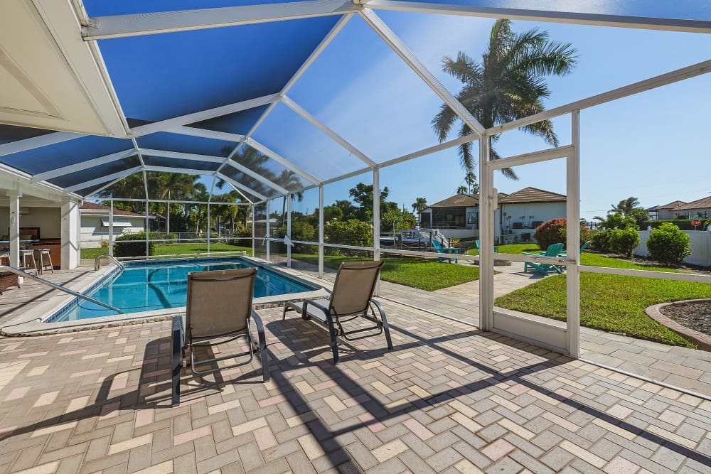 The screened heated pool and waterfront backyard at South Del Prado Point create a peaceful setting for swimming, relaxing, and enjoying sunny Florida days. A favorite home base featured in our Florida travel guide for travelers looking to unwind.